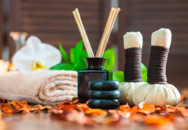 Spa arka planı. Havlu, mumlar, çiçekler, aroma çubukları, masaj taşları ve bitkisel toplar. Masaj, oryantal terapi, refah ve meditasyon.