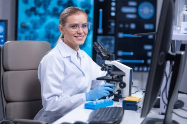 Profesyonel kadın bilim adamı bir bilimsel araştırma laboratuvarında aşı üzerinde çalışıyor. Genetik mühendisliği işyeri. Teknoloji ve bilim konsepti.
