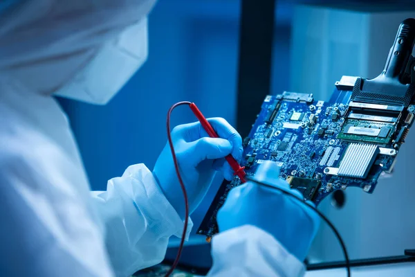 Microelectronics engineer works in a modern scientific laboratory on computing systems and microprocessors. Electronic factory worker is testing the motherboard and coding the firmware. — Stock Photo, Image