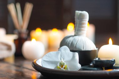 Spa arka planı. Havlu, mumlar, çiçekler, aroma çubukları, masaj taşları ve bitkisel toplar. Masaj, oryantal terapi, refah ve meditasyon.