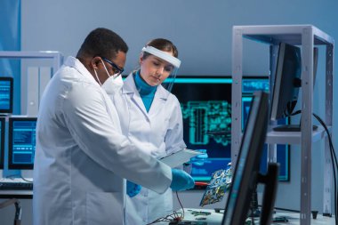 Çeşitli mikro elektronik mühendisleri bilim laboratuarında güncel gelişmeleri tartışıyor. Mikroişlemci tasarımcılarının işyeri. Geleceğin yenilikleri ve icatları kavramı.