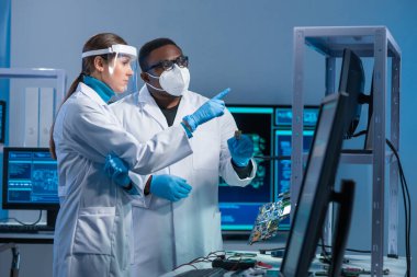 Çeşitli mikro elektronik mühendisleri modern bir bilim laboratuvarında güncel gelişmeleri tartışıyor. Mikroişlemci tasarımcılarının işyeri. Geleceğin yenilikleri ve icatları kavramı.