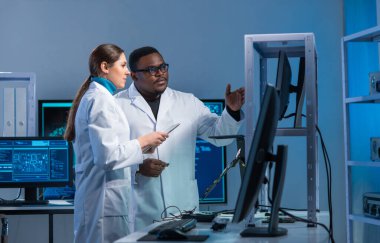 Çeşitli mikro elektronik mühendisleri modern bir bilim laboratuvarında güncel gelişmeleri tartışıyor. Mikroişlemci tasarımcılarının işyeri. Geleceğin yenilikleri ve icatları kavramı.