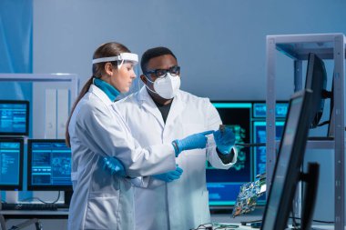 Çeşitli mikro elektronik mühendisleri modern bir bilim laboratuvarında güncel gelişmeleri tartışıyor. Mikroişlemci tasarımcılarının işyeri. Geleceğin yenilikleri ve icatları kavramı.