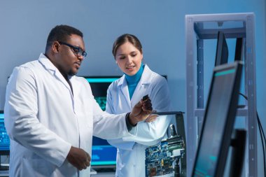 Çeşitli mikro elektronik mühendisleri bilim laboratuarında güncel gelişmeleri tartışıyor. Mikroişlemci tasarımcılarının işyeri. Geleceğin yenilikleri ve icatları kavramı.