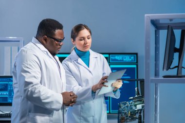 Çeşitli mikro elektronik mühendisleri bilim laboratuarında güncel gelişmeleri tartışıyor. Mikroişlemci tasarımcılarının işyeri. Geleceğin yenilikleri ve icatları kavramı.