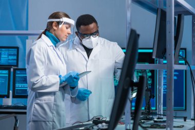 Çeşitli mikro elektronik mühendisleri bilim laboratuarında güncel gelişmeleri tartışıyor. Mikroişlemci tasarımcılarının işyeri. Geleceğin yenilikleri ve icatları kavramı.