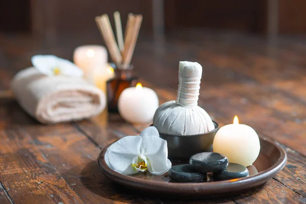 Fond de spa. Serviette, bougies, fleurs, bâtons d'arôme, pierres de massage et boules à base de plantes. Massage, thérapie orientale, bien-être et méditation. — Photo