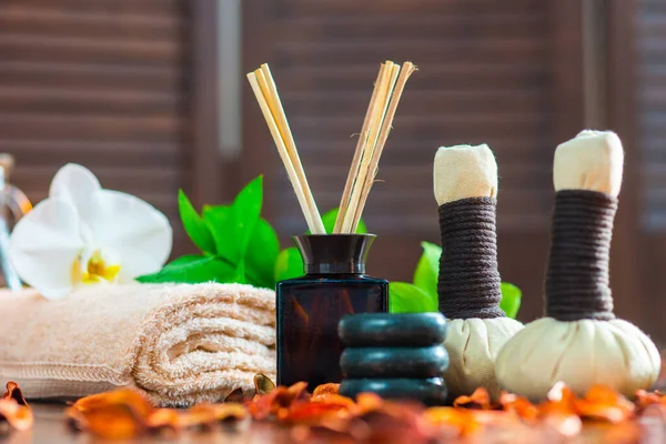 Spa bakgrund. Handduk, ljus, blommor, doftpinnar, massagestenar och örtbollar. Massage, orientalisk terapi, välbefinnande och meditation. — Stockfoto