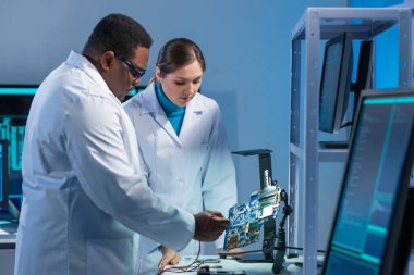 Çeşitli mikro elektronik mühendisleri bilim laboratuarında güncel gelişmeleri tartışıyor. Mikroişlemci tasarımcılarının işyeri. Geleceğin yenilikleri ve icatları kavramı.