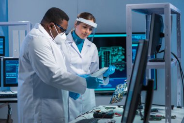 Çeşitli mikro elektronik mühendisleri bilim laboratuarında güncel gelişmeleri tartışıyor. Mikroişlemci tasarımcılarının işyeri. Geleceğin yenilikleri ve icatları kavramı.