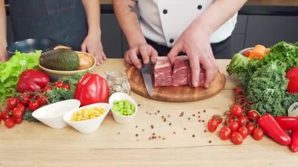 Genç kadın ve erkek yemek hazırlar ve bir yemek programı sunarlar. Blogcular mutfaktan yayın yapıyor. Sağlıklı yemek hazırlığı. — Stok video