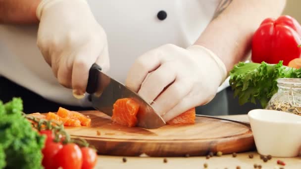 El joven chef está cortando zanahorias en una cocina moderna. El hombre prepara comida en casa. Cocinar alimentos saludables. — Vídeos de Stock