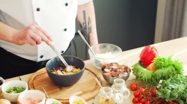 Young modern bir mutfakta dürtme kasesi hazırlıyor. Adam evde yemek hazırlıyor. Sağlıklı yemek pişirmek..