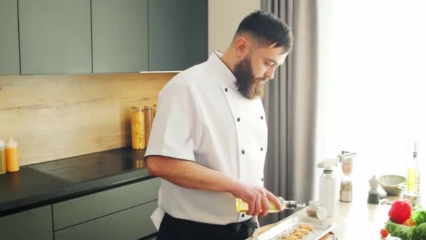 Jonge koks zalmvissen met een gasbrander in een moderne keuken. De man bereidt thuis eten. Gezond voedsel koken. — Stockvideo