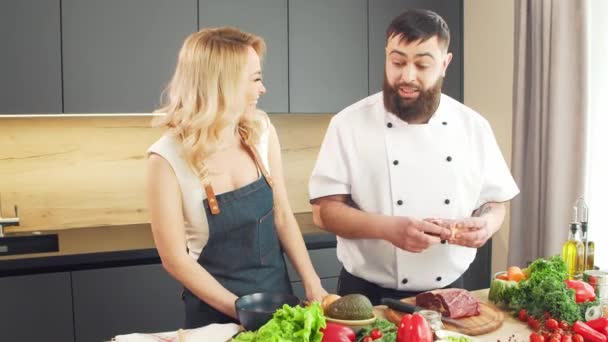 Mujer joven y hombre preparan comida y organizan un programa de cocina. Los bloggers fluyen desde la cocina. Preparación de alimentos saludables. — Vídeos de Stock