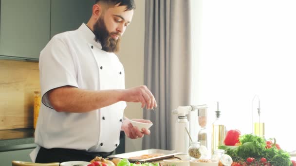 Jóvenes cocineros salmón pescado con un quemador de gas en una cocina moderna. El hombre prepara comida en casa. Cocinar alimentos saludables. — Vídeos de Stock