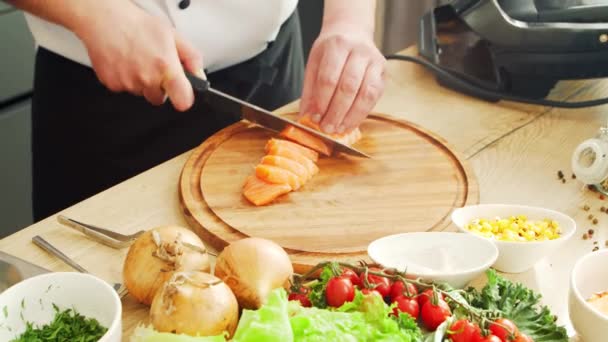 Les jeunes cuisinent du saumon avec un brûleur à gaz dans une cuisine moderne. Il prépare à manger à la maison. Cuisiner des aliments sains. — Video