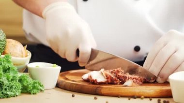 Genç aşçı modern bir mutfakta ahtapot kesiyor. Adam evde yemek hazırlıyor. Sağlıklı yemek pişirmek..