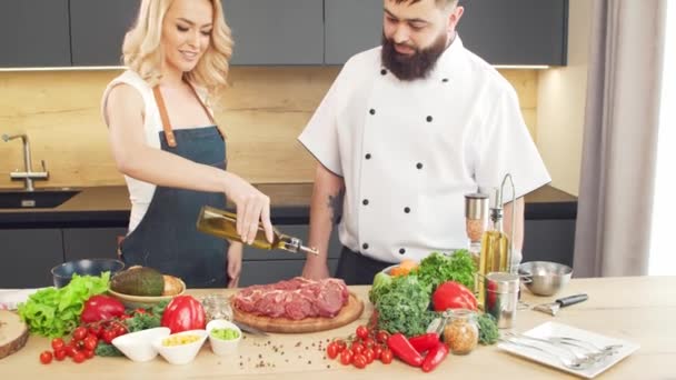 Mladá žena a muž připravit jídlo a hostit kuchařskou show. Bloggeři proudí z kuchyně. Zdravá výživa. — Stock video