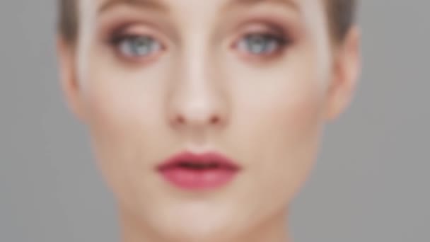 Portrait studio de jeune, belle et naturelle femme sur fond gris. lifting du visage, cosmétiques et maquillage. — Video