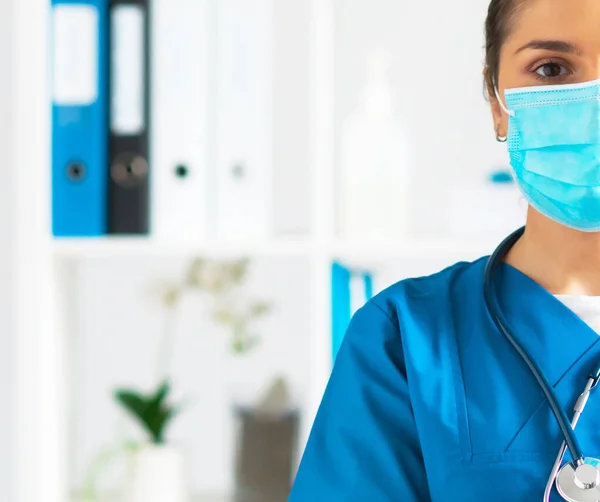 Профессиональный врач, работающий в больничном кабинете, Портрет молодой и привлекательной женщины-врача в защитной маске. — стоковое фото