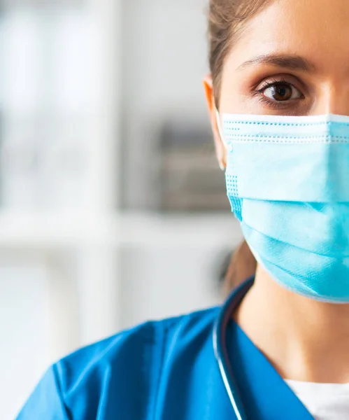 병원에서 근무하는 전문 의사, 보호용 마스크를 쓰고 있는 젊고 매력적 인 여성 의사의 모습. — 스톡 사진