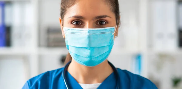 Professionele arts werkzaam in het ziekenhuis kantoor, Portret van jonge en aantrekkelijke vrouwelijke arts met beschermend masker. — Stockfoto