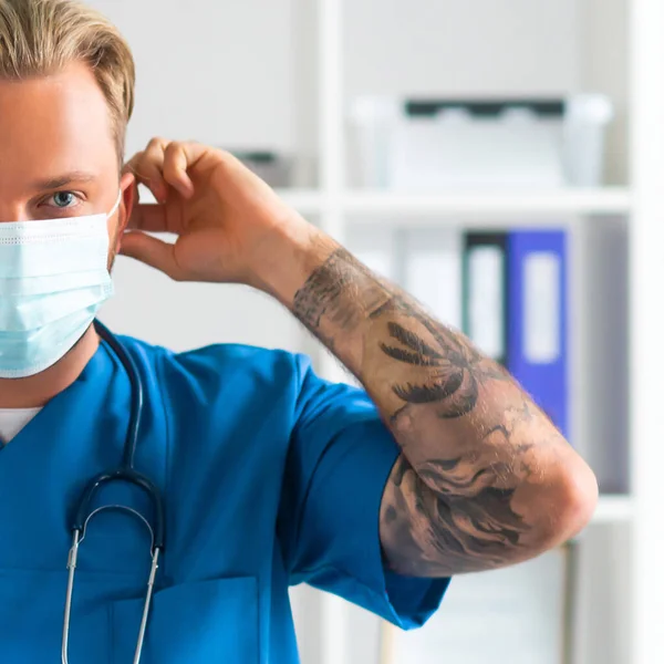 Επαγγελματίας ιατρός στο γραφείο του νοσοκομείου, Πορτρέτο του νεαρού και με αυτοπεποίθηση γιατρού με προστατευτική μάσκα. — Φωτογραφία Αρχείου