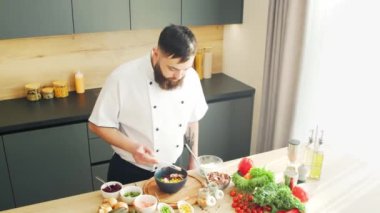 Young modern bir mutfakta dürtme kasesi hazırlıyor. Adam evde yemek hazırlıyor. Sağlıklı yemek pişirmek..