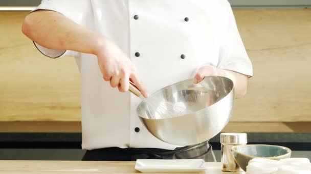 Young prepara un postre de merengue en una cocina moderna. El hombre prepara comida en casa. Cocinar alimentos saludables. — Vídeos de Stock