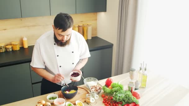 Young prépare un poke bowl dans une cuisine moderne. Il prépare à manger à la maison. Cuisiner des aliments sains. — Video