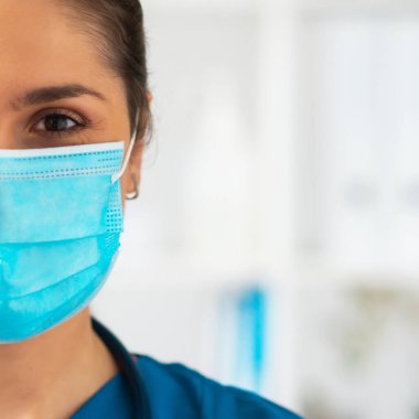 Hastane ofisinde çalışan profesyonel tıp doktoru koruyucu maskeli genç ve çekici kadın doktorların portresi..