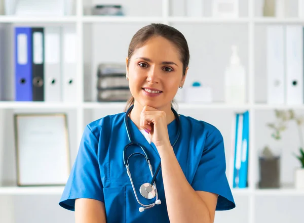 Berufsärztin im Krankenhausbüro, Porträt einer jungen und attraktiven Ärztin mit Schutzmaske. — Stockfoto