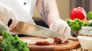 Genç aşçı modern bir mutfakta ahtapot kesiyor. Adam evde yemek hazırlıyor. Sağlıklı yemek pişirmek..