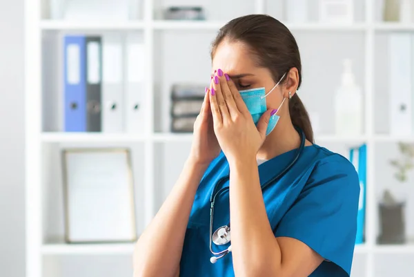 Professional medical doctor working in hospital office, Portrait of young and attractive female physician in protective mask. — Stock Photo, Image