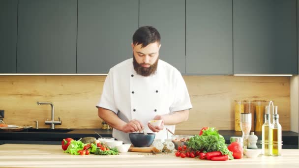 Young prépare un poke bowl dans une cuisine moderne. Il prépare à manger à la maison. Cuisiner des aliments sains. — Video