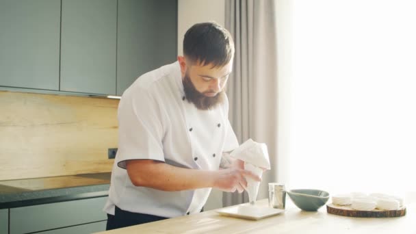 Young prepara un postre de merengue en una cocina moderna. El hombre prepara comida en casa. Cocinar alimentos saludables. — Vídeos de Stock