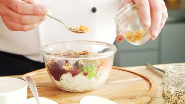 Young prépare un poke bowl dans une cuisine moderne. Il prépare à manger à la maison. Cuisiner des aliments sains. — Video