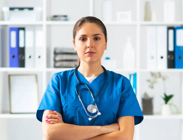 Berufsärztin im Krankenhausbüro, Porträt einer jungen und attraktiven Ärztin mit Schutzmaske. — Stockfoto