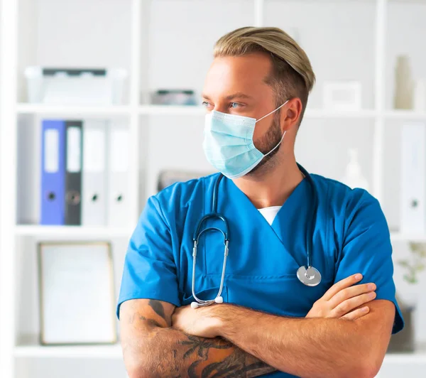 Médico profesional en consultorio hospitalario, Retrato de médico joven y confiado en máscara protectora. — Foto de Stock