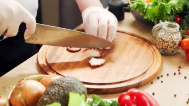 Genç aşçı modern bir mutfakta ahtapot kesiyor. Adam evde yemek hazırlıyor. Sağlıklı yemek pişirmek..