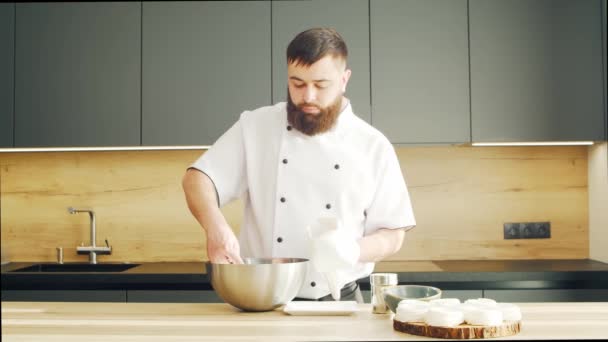 Young prepara il dessert alla meringa in una cucina moderna. L'uomo prepara il cibo a casa. Cucinare cibo sano. — Video Stock