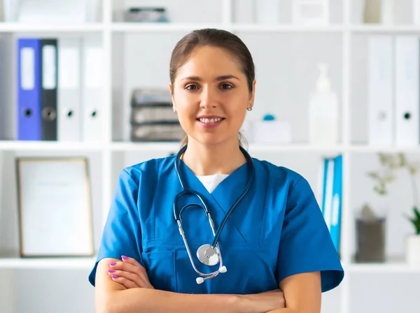 Berufsärztin im Krankenhausbüro, Porträt einer jungen und attraktiven Ärztin mit Schutzmaske. — Stockfoto