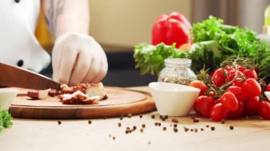 Genç aşçı modern bir mutfakta ahtapot kesiyor. Adam evde yemek hazırlıyor. Sağlıklı yemek pişirmek..