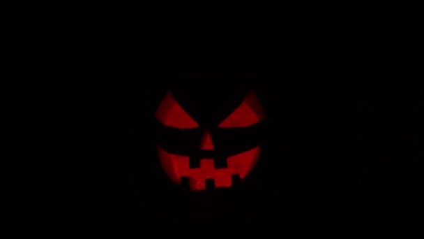 Skrattande pumpa på en mörk bakgrund. Halloween, häxeri och magi. — Stockvideo