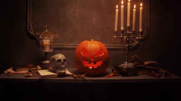 Läskigt skrattande pumpa och gammal skalle på antik gotisk öppen spis. Halloween, häxeri och magi. — Stockvideo