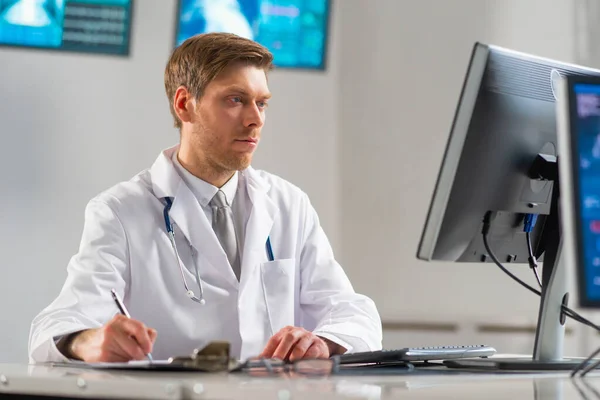 Professioneller Arzt, der im Krankenhausbüro mit Computertechnologie arbeitet. Medizin, Kardiologie und Gesundheitswesen. — Stockfoto