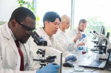 Laboratuvarda çalışan bilim adamları ve öğrenciler. Doktor stajyerlere araştırma yapmayı öğretiyor. Biyoteknoloji, kimya, bakteriyoloji, viroloji, DNA ve sağlık hizmetleri kavramı.