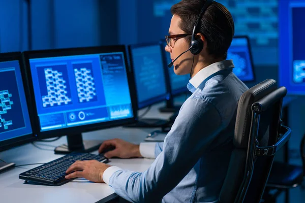 De medewerker van het callcenter spreekt met de klant per headset. Werkplaats van de functionaris voor professionele ondersteuning. — Stockfoto